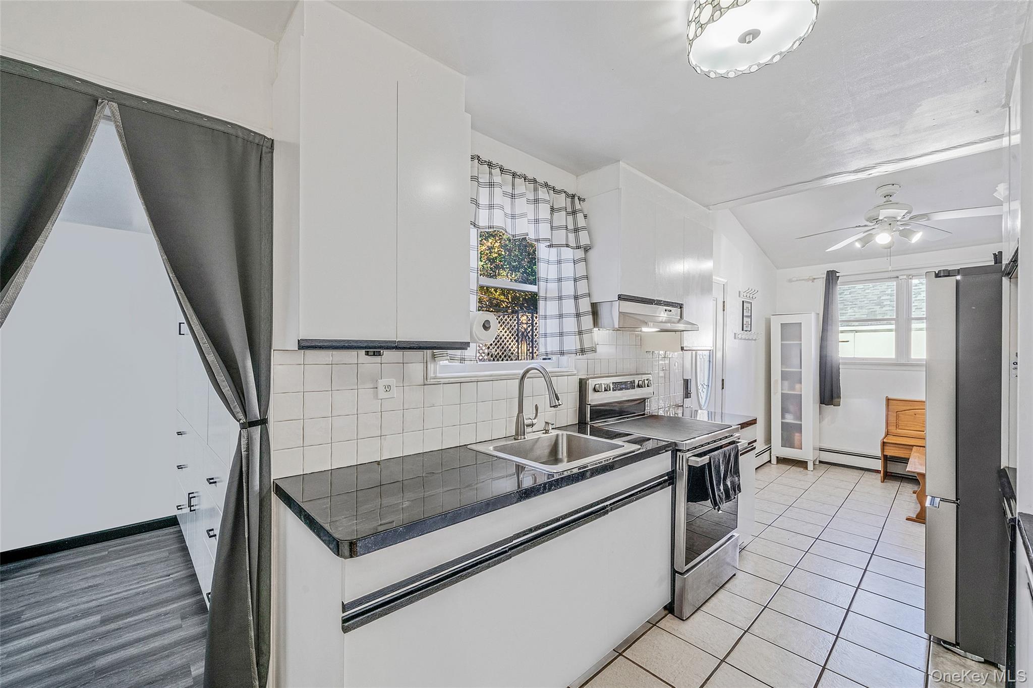 267 Dogwood Road West Mastic Beach, NY 11951 - Photo 21 of 30 a kitchen with stainless steel appliances granite countertop a sink stove and refrigerator
