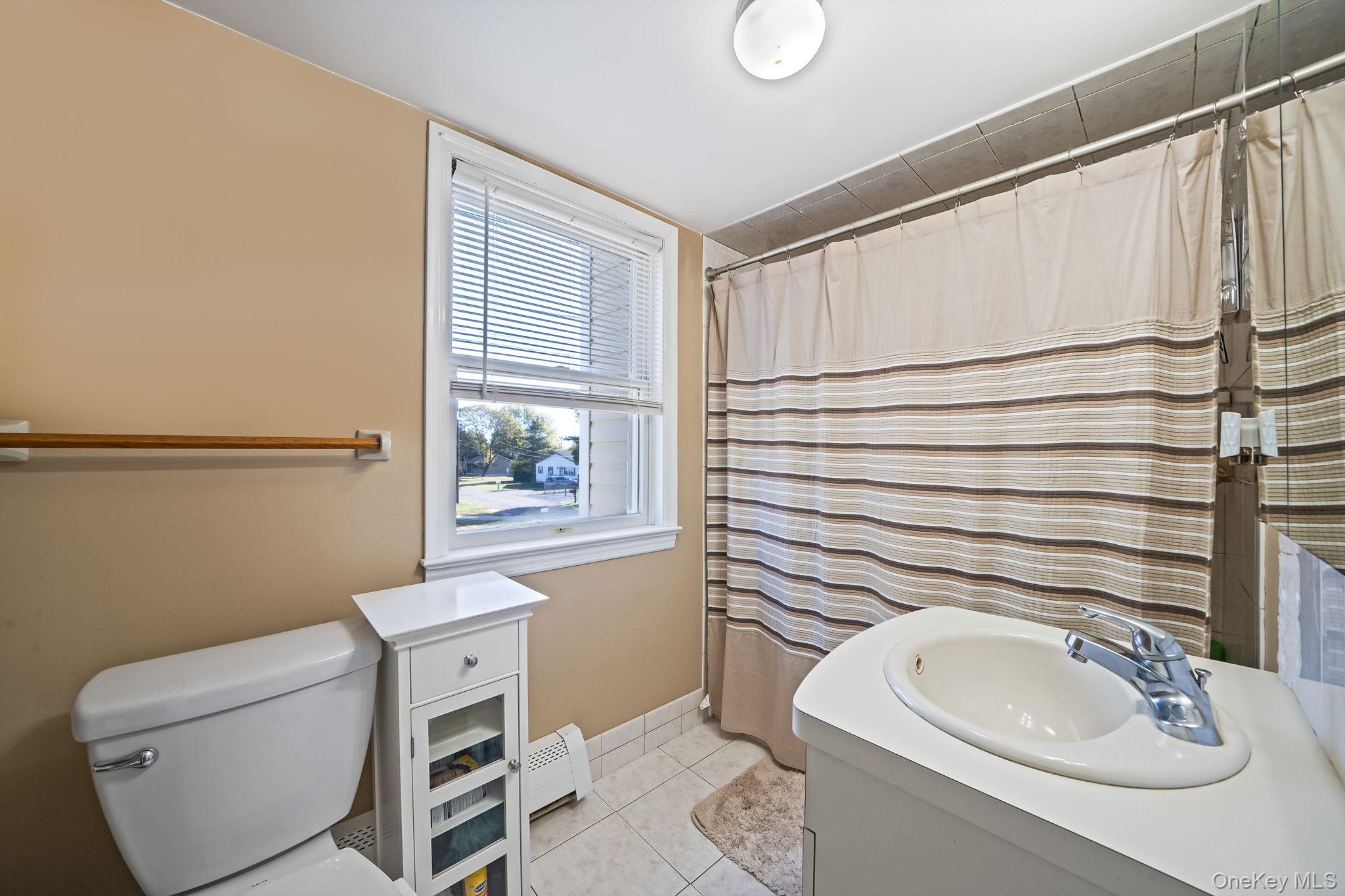 267 Dogwood Road West Mastic Beach, NY 11951 - Photo 30 of 30 a bathroom with a sink a toilet and tub