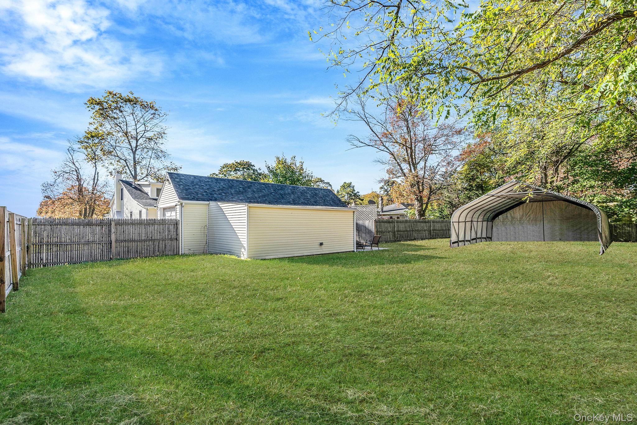 267 Dogwood Road West Mastic Beach, NY 11951 - Photo 9 of 30 a view of a wooden house with a yard and large tree