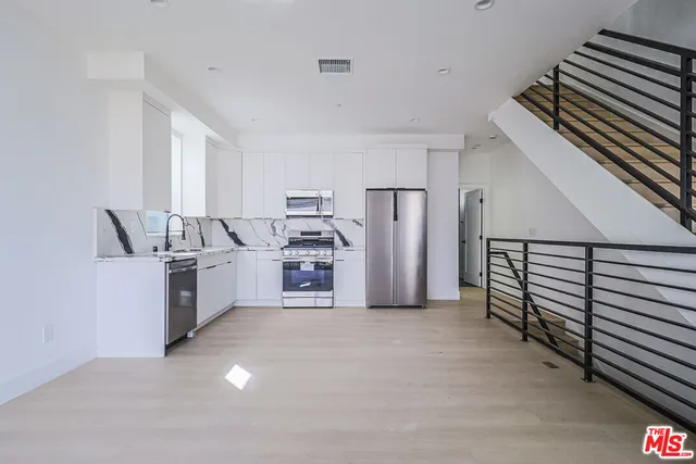 a kitchen with refrigerator and cabinets