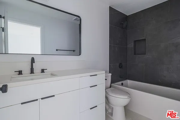 a bathroom with a sink toilet vanity and tub