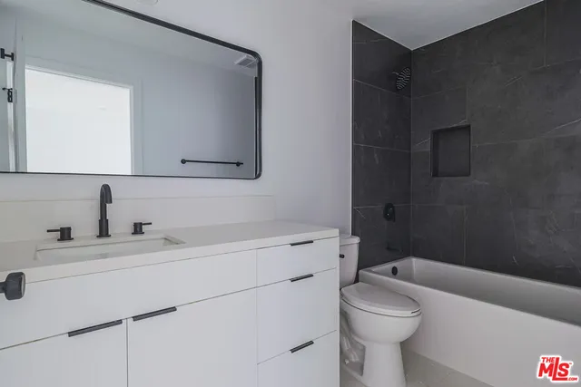 a bathroom with a sink toilet vanity and tub