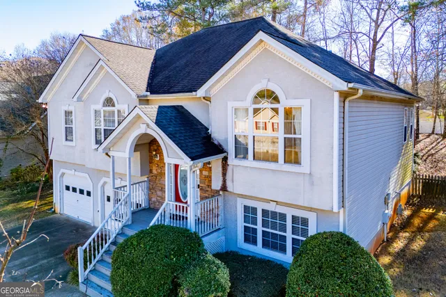 a view of a white house with large windows and a yard