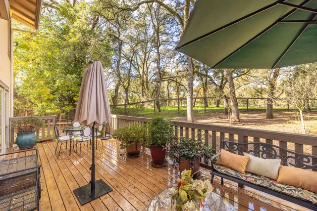 a view of a balcony with chairs and wooden floor