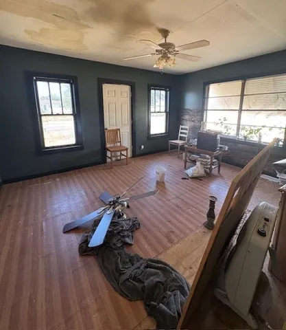 a living room with furniture floor to ceiling window and wooden floor