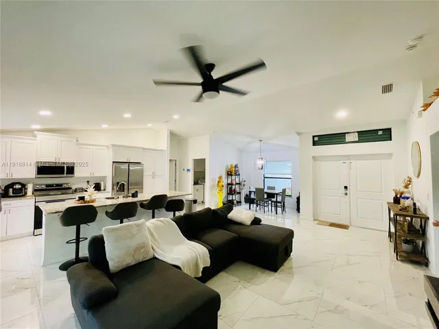 a living room with lots of furniture and kitchen view