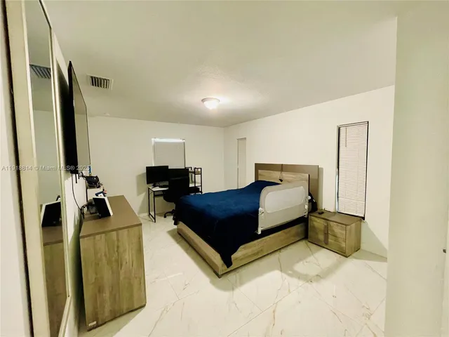 a spacious bedroom with a bed and a dresser