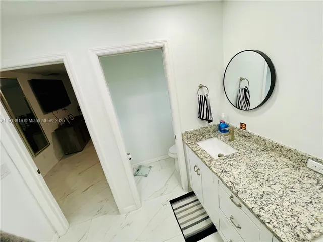 a bathroom with a sink a toilet and a mirror