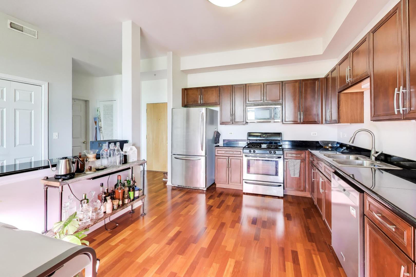500 East St Charles Road, Unit 510 Lombard, IL 60148 - Photo 12 of 28 a kitchen with stainless steel appliances a stove a sink dishwasher a refrigerator and cabinets with wooden floor