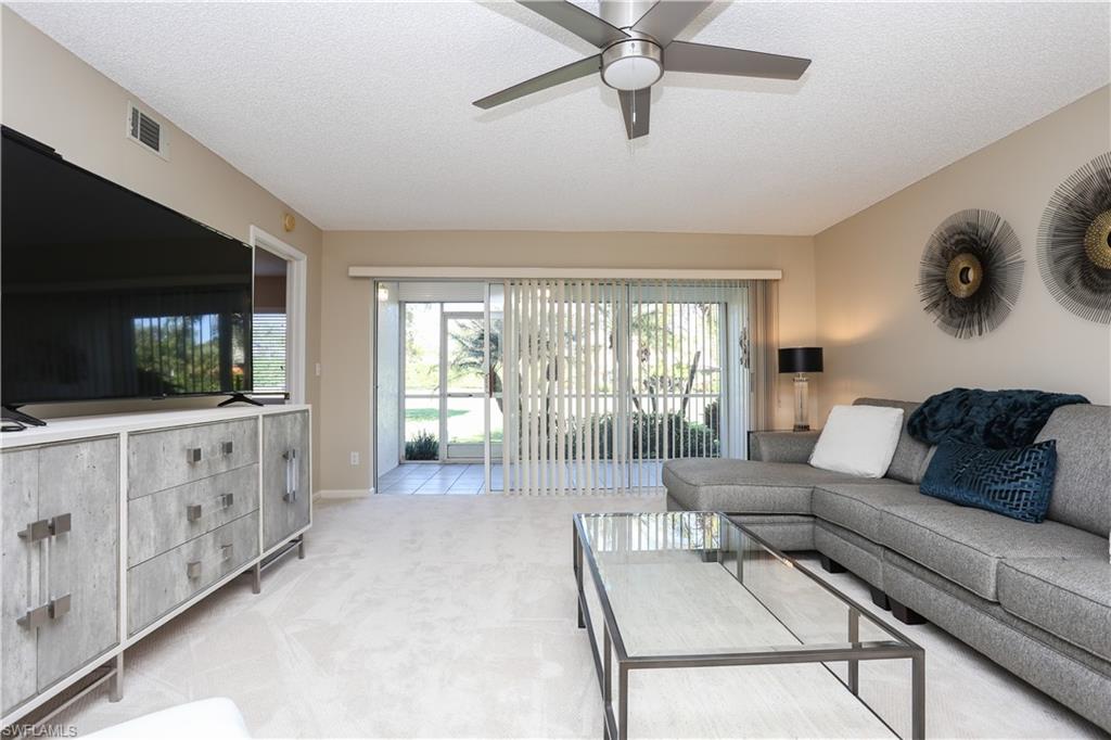 5908 Cranbrook Way, Unit I103 Naples, FL 34112 - Photo 14 of 26 a living room with furniture and a flat screen tv