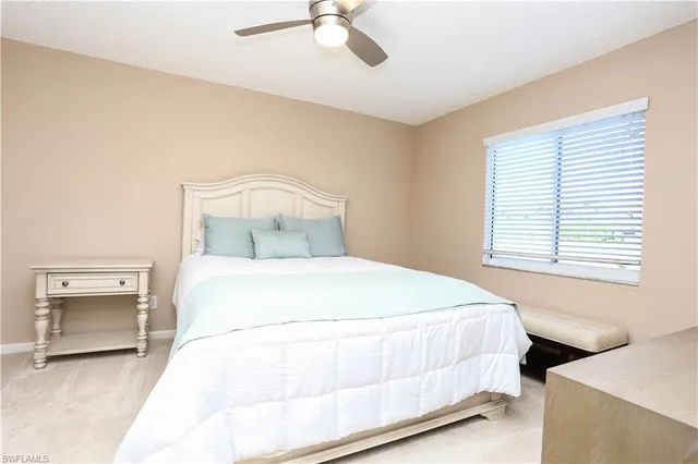 a bedroom with a bed and a ceiling fan