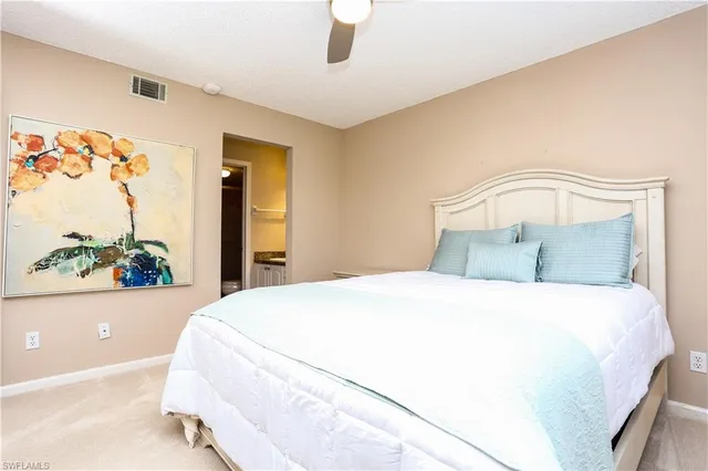 a bedroom with a bed and a painting on the wall