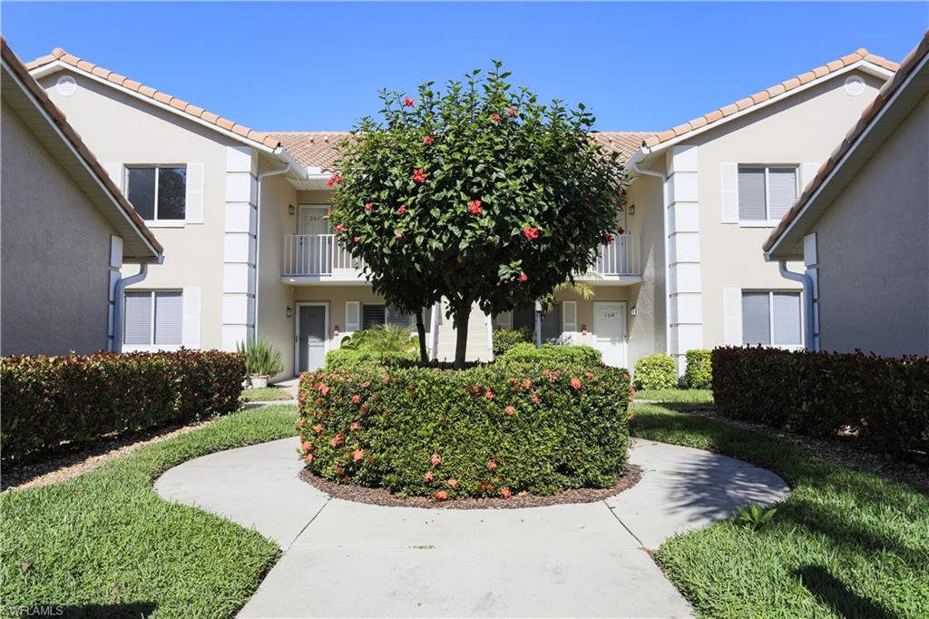 5908 Cranbrook Way, Unit I103 Naples, FL 34112 - Photo 3 of 26 a front view of a house with garden