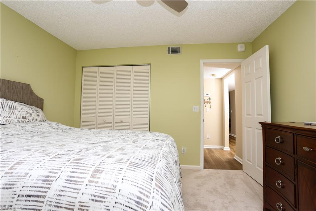 5908 Cranbrook Way, Unit I103 Naples, FL 34112 - Photo 6 of 26 a bedroom with a bed and a dresser