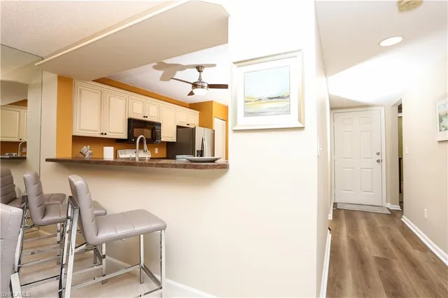 a kitchen with stainless steel appliances kitchen island granite countertop a refrigerator and microwave