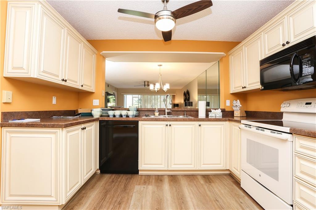 5908 Cranbrook Way, Unit I103 Naples, FL 34112 - Photo 10 of 26 a kitchen with stainless steel appliances granite countertop a stove and a refrigerator