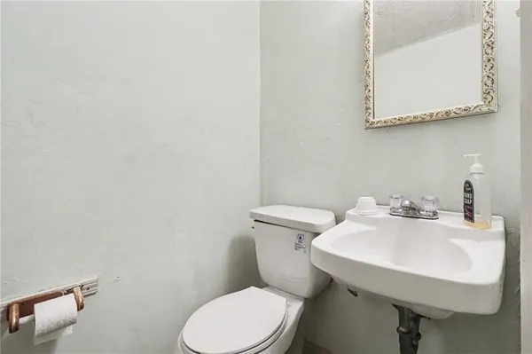 a bathroom with a sink a toilet and mirror
