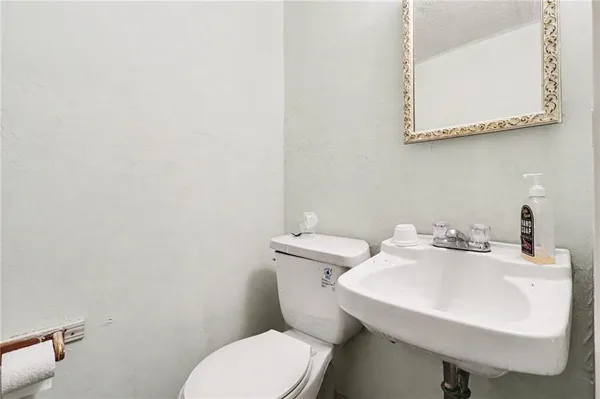 a bathroom with a sink a toilet and mirror