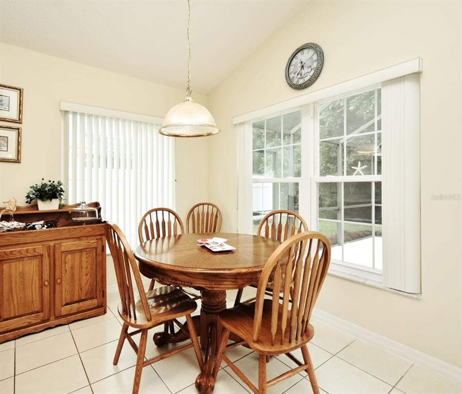 2591 Oneida Loop Kissimmee, FL 34747 - Photo 13 of 48 a dining room with furniture a chandelier and wooden floor