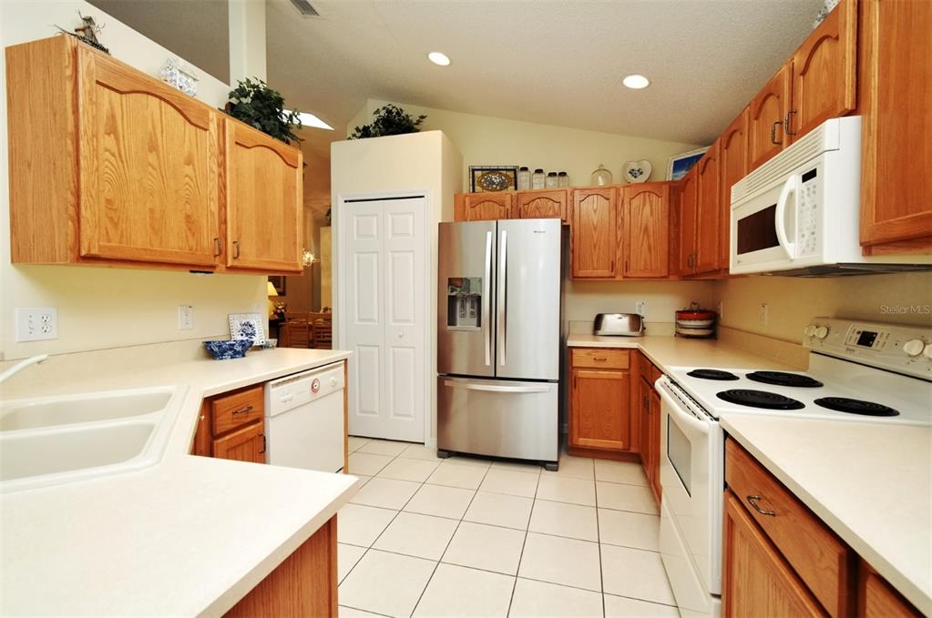 2591 Oneida Loop Kissimmee, FL 34747 - Photo 17 of 48 a kitchen with a sink a refrigerator and cabinets