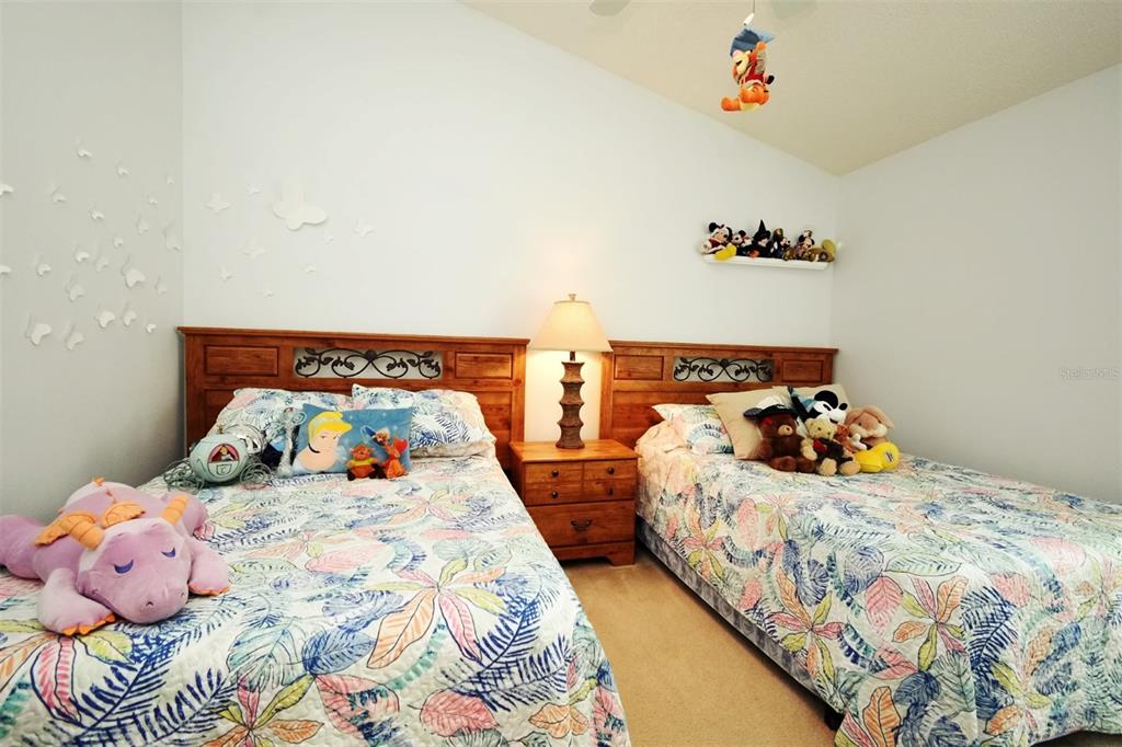2591 Oneida Loop Kissimmee, FL 34747 - Photo 25 of 48 a bedroom with two beds and a potted plant
