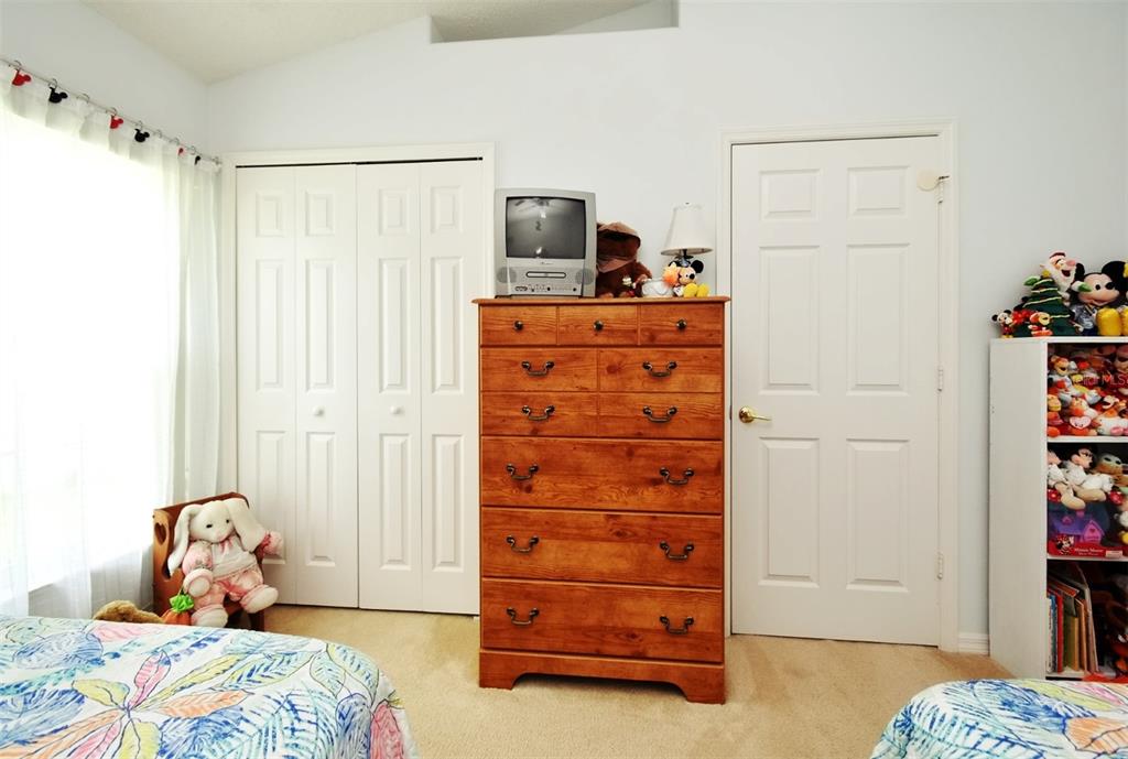2591 Oneida Loop Kissimmee, FL 34747 - Photo 26 of 48 a bedroom with a bed and a dresser