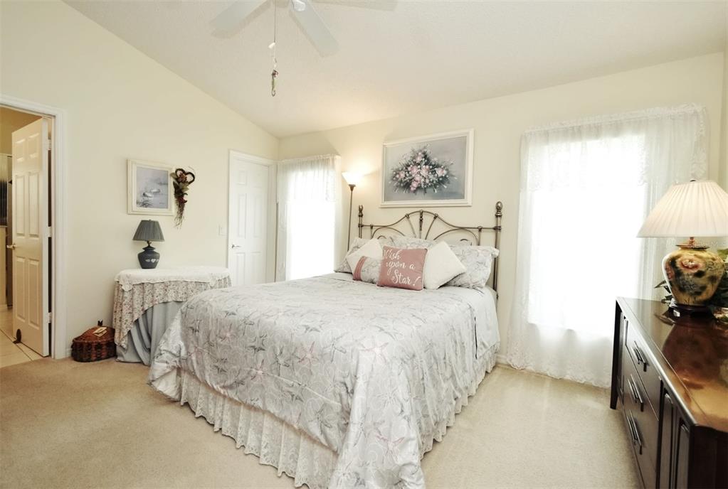 2591 Oneida Loop Kissimmee, FL 34747 - Photo 27 of 48 a bedroom with a bed and a chandelier