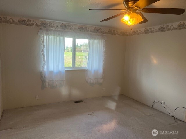 19944 Carper Road Southwest Rochester, WA 98579 - Photo 7 of 27 en empty room with windows and chandelier fan