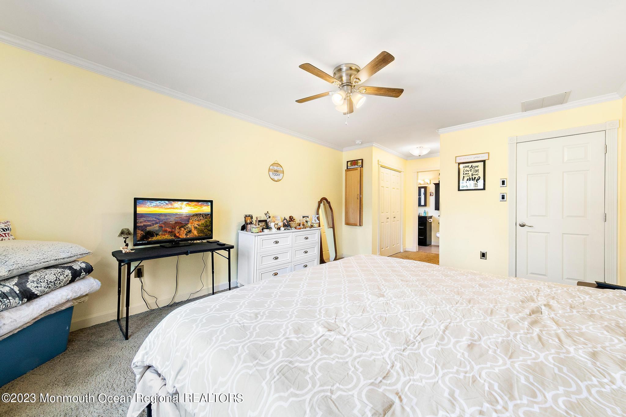 128 Dolphin Road Manahawkin, NJ 08050 - Photo 21 of 34 a bedroom with a bed and a chandelier