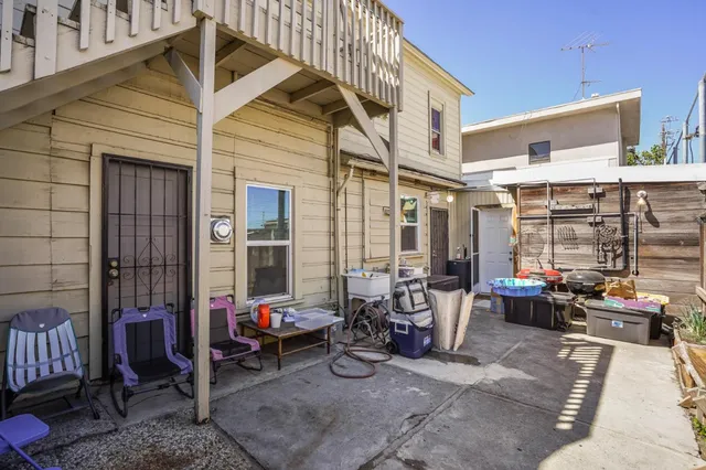 a kitchen with stainless steel appliances kitchen island granite countertop a dining table chairs and a refrigerator
