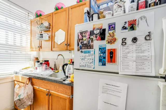 a kitchen with stainless steel appliances a dining table chairs and refrigerator