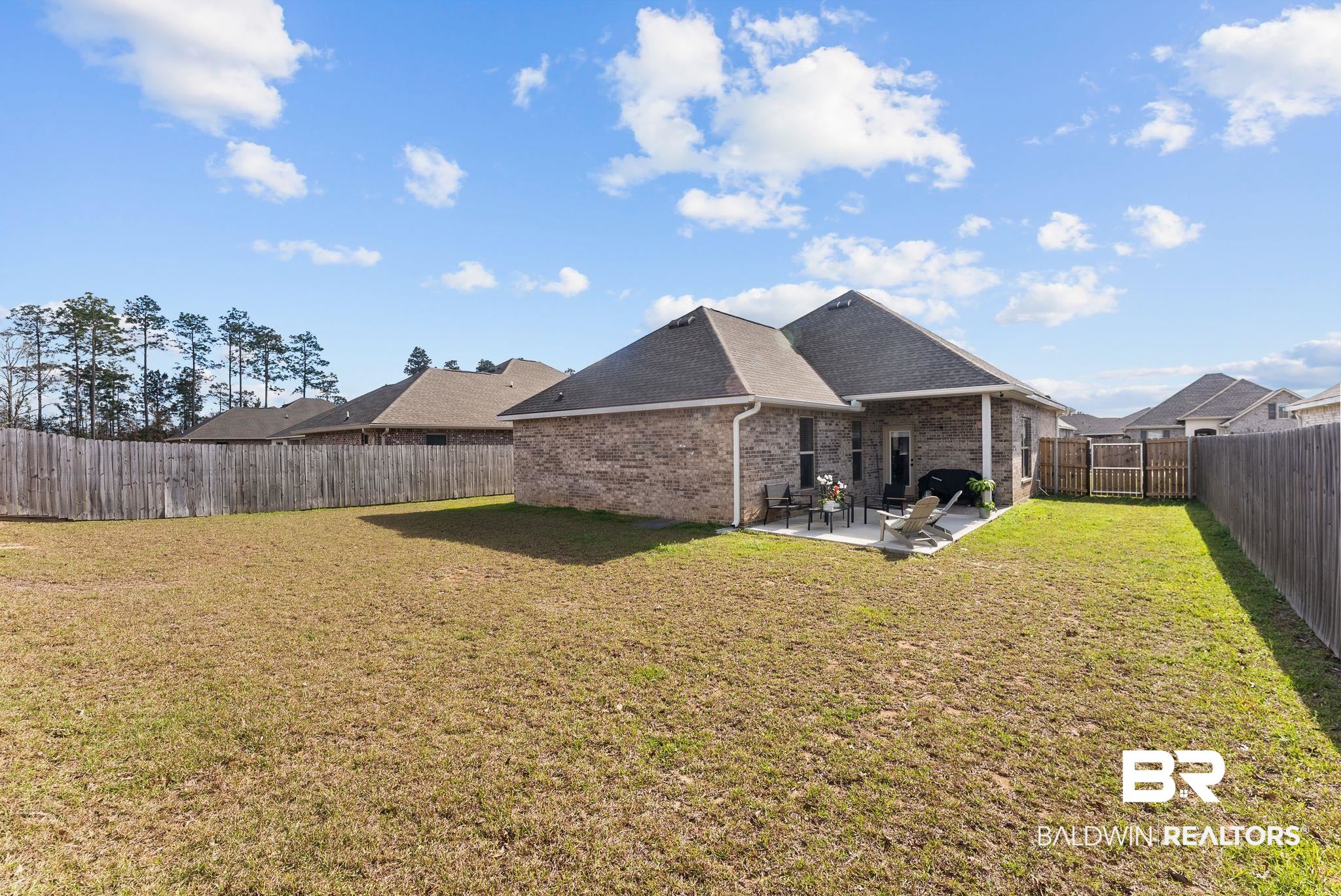 10745 Brodick Loop Daphne, AL 36527 - Photo 26 of 39 Back of property with a patio area, brick siding, a shingled roof, and a fenced backyard