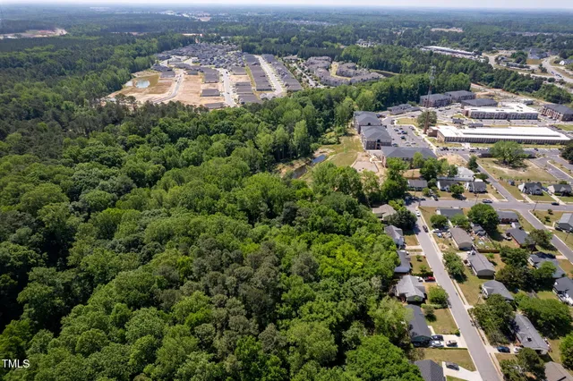 an aerial view of residential houses with outdoor space and trees