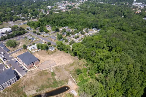 a aerial view of a house with a yard and large trees