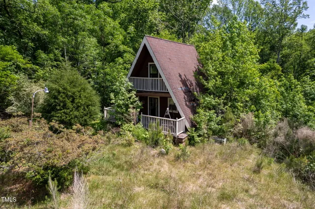 an aerial view of a house with yard and seating space