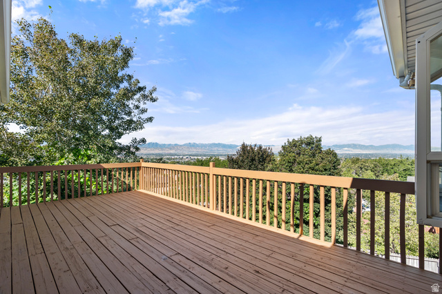 11934 South Cedar Ridge Road Sandy, UT 84094 - Photo 3 of 58 Expansive wood deck with a full wood railing, offering a distant mountain backdrop
