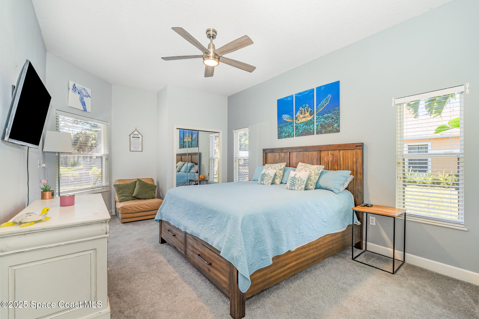 1617 Sun Point Place Merritt Island, FL 32952 - Photo 29 of 42 a bedroom with a bed a couch and a flat screen tv