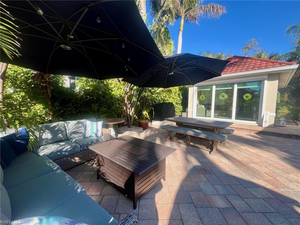 5003 Coach Lane Naples, FL 34114 - Photo 8 of 17 a view of a patio with table and chairs under an umbrella