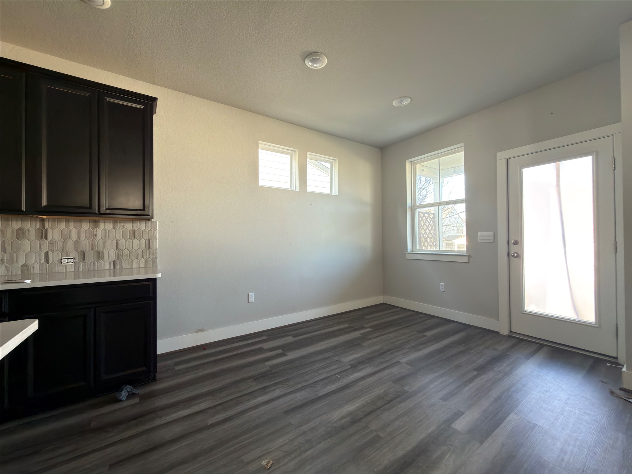 7312 Acela Trail Austin, TX 78744 - Photo 6 of 26 Unfurnished dining area with baseboards and dark wood-style flooring