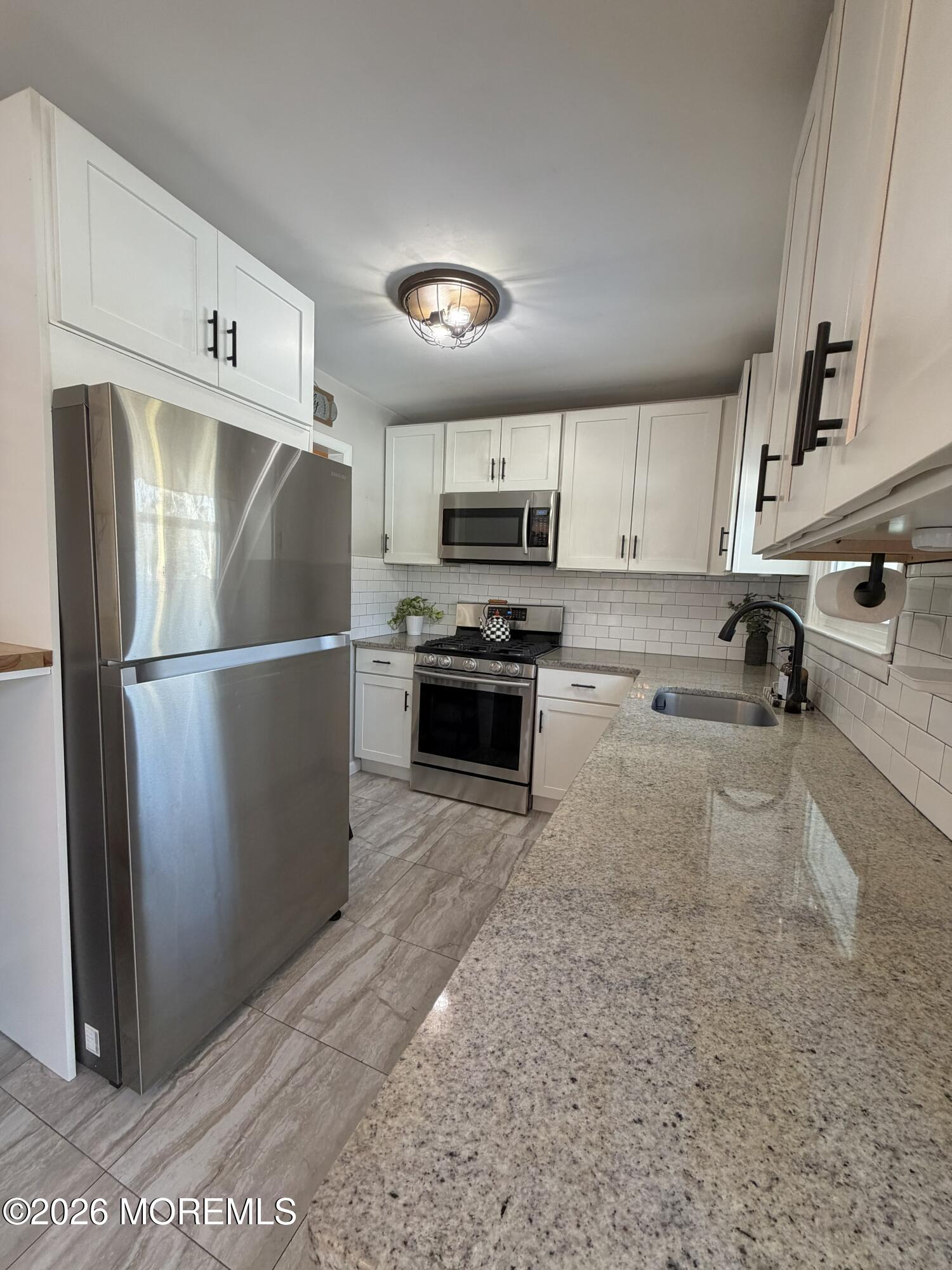 43 Lake Drive Howell, NJ 07731 - Photo 16 of 22 a kitchen with stainless steel appliances granite countertop a refrigerator a stove a sink and a microwave