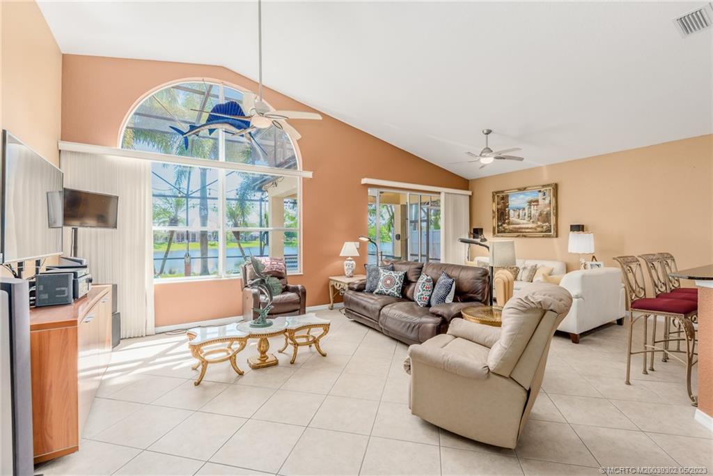 2032 Northwest Marsh Rabbit Lane Stuart, FL 34994 - Photo 15 of 30 a living room with furniture a fireplace and a flat screen tv
