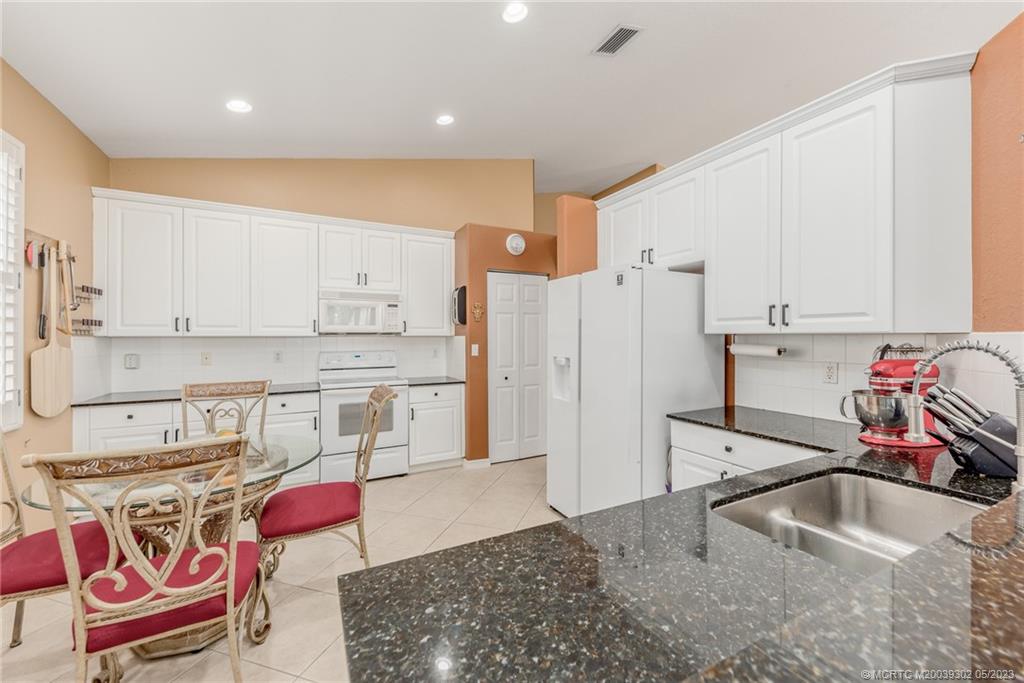 2032 Northwest Marsh Rabbit Lane Stuart, FL 34994 - Photo 17 of 30 a kitchen with stainless steel appliances granite countertop a sink and a refrigerator