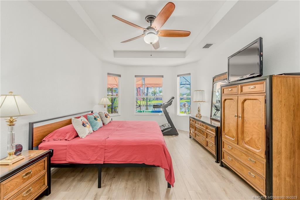 2032 Northwest Marsh Rabbit Lane Stuart, FL 34994 - Photo 20 of 30 a bedroom with a bed dresser and a flat tv screen
