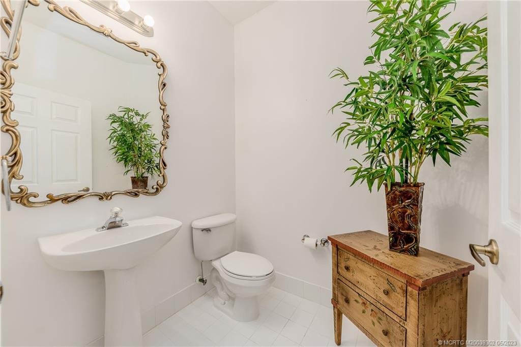 2032 Northwest Marsh Rabbit Lane Stuart, FL 34994 - Photo 24 of 30 a bathroom with a toilet a sink and a mirror