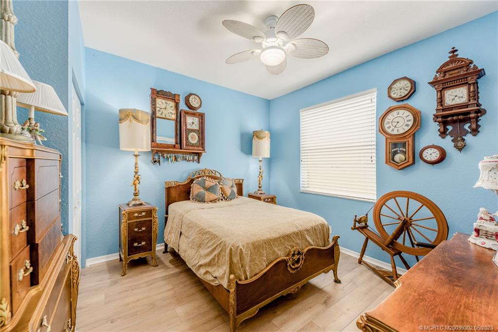 2032 Northwest Marsh Rabbit Lane Stuart, FL 34994 - Photo 27 of 30 a bedroom with a bed a chandelier and a window