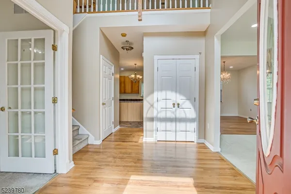 a view of a hallway with wooden floor and living room