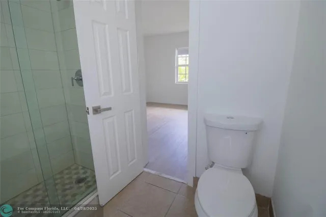 a white toilet sitting in a bathroom next to a window