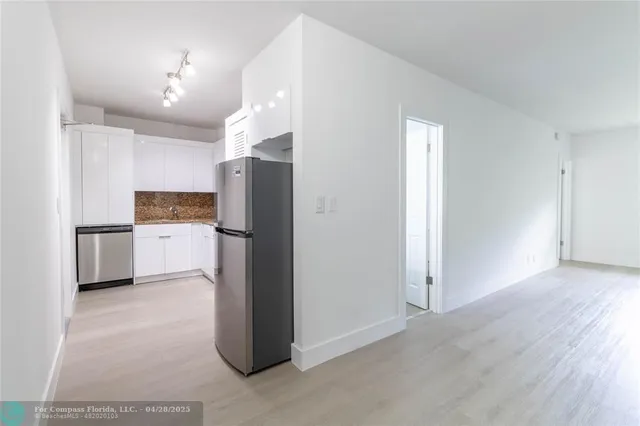 a kitchen with a refrigerator a sink and a microwave