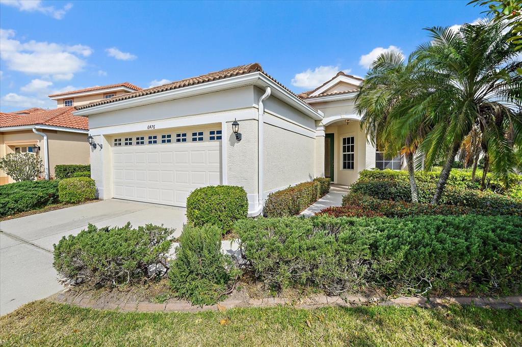 6476 Rookery Circle Bradenton, FL 34203 - Photo 33 of 44 a view of a house with potted plants and a large tree