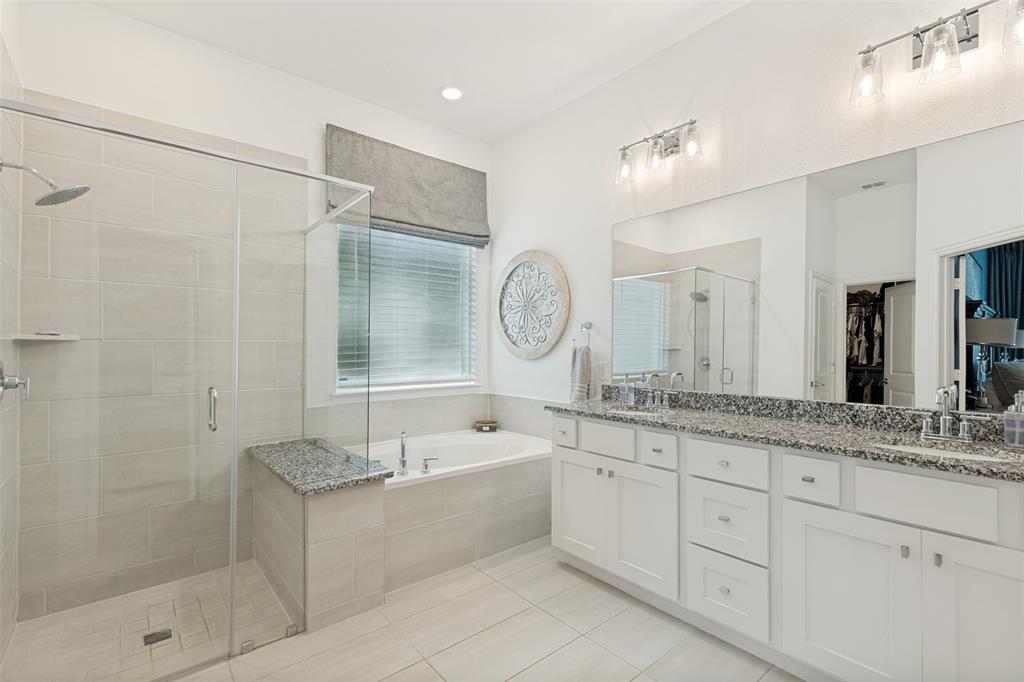 229 Savannah Lane Oak Point, TX 75068 - Photo 16 of 26 a spacious bathroom with a granite countertop sink mirror and shower